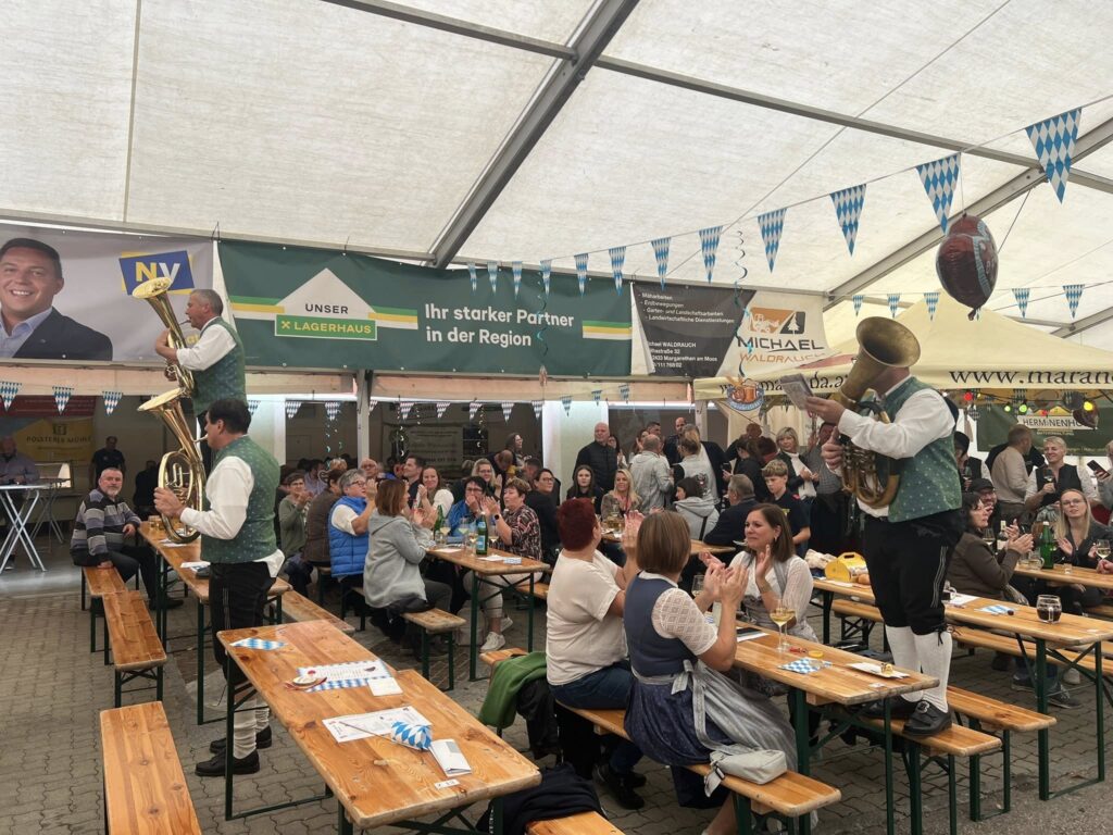 Ist möglicherweise ein Bild von Dirndlrock, Menschenmasse und Text „NV 2 UNSER LAGERHAUS LAGE IhrstarkerPartner Ihr starker Partner inderRegion in der Region tstor M MICHAEL Da Dana www. www.maran HERMINENHO“